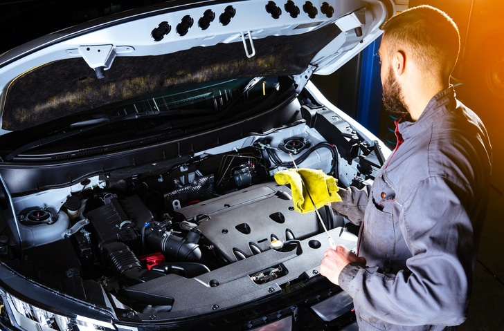 Mechaniker prüft Motorraum bei Motorschaden